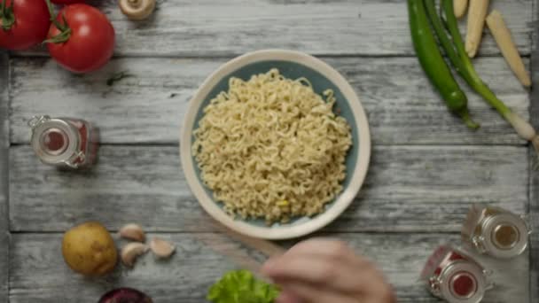 Persona anónima que toma fideos con palillos sobre la mesa — Vídeo de stock