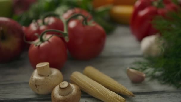 Reifes Gemüse und Kräuter in der Nähe heller Zitrusfrüchte auf dem Tisch. Vegetarisches Konzept — Stockvideo