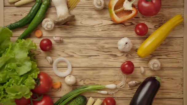 De mans hand zet de smartphone op een houten tafel met groenten — Stockvideo