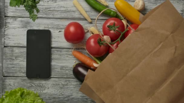 Verduras girando cerca de teléfonos inteligentes y comestibles. Concepto vegetariano . — Vídeos de Stock