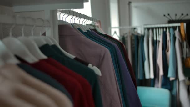Cintres avec des vêtements tendance dans le magasin . — Video