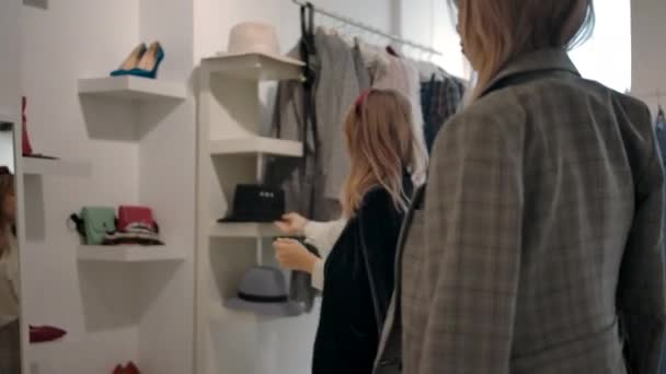 Nachdenklicher junger Verkäufer hilft Kunden bei Kleiderwahl in modernem Showroom. — Stockvideo