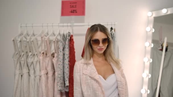 Mujer rubia disfrutando de las ventas en boutique . — Vídeo de stock