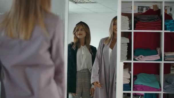 Trendy vrienden dansen in de buurt van spiegel in winkel. — Stockvideo