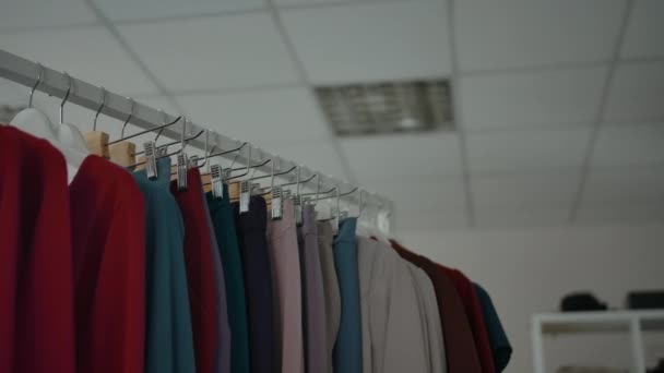 Diverse kleding op rails in de winkel. — Stockvideo