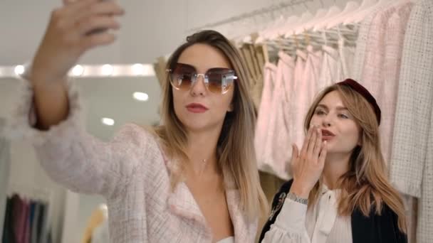 Fiatal stílusos nők felvétel videó okostelefon butik. — Stock videók