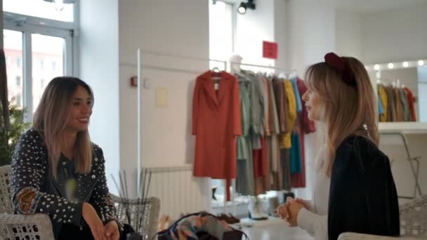 Стильные подружки разговаривают в магазине одежды — стоковое видео