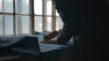 Daha fazla üretim için süet kumaşı düzleştiren kadının elleri.