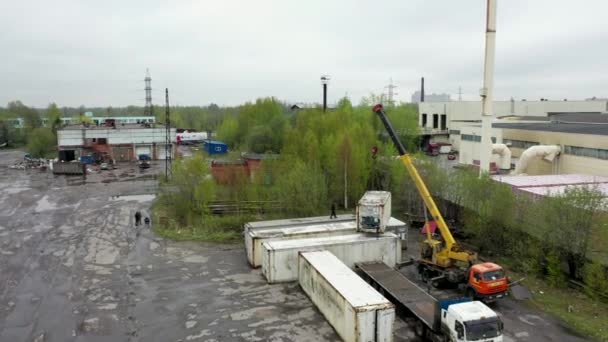 Повітряне відео крана, який розвантажує контейнер з вантажівки — стокове відео