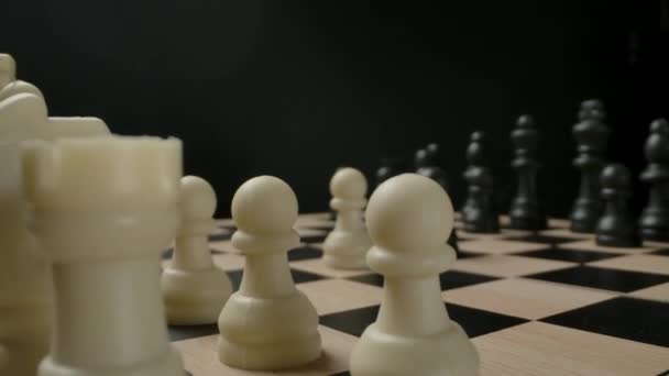 Mans hand moving chess figure knight from first line. Macro shot of small plastic chess. — Stock Video