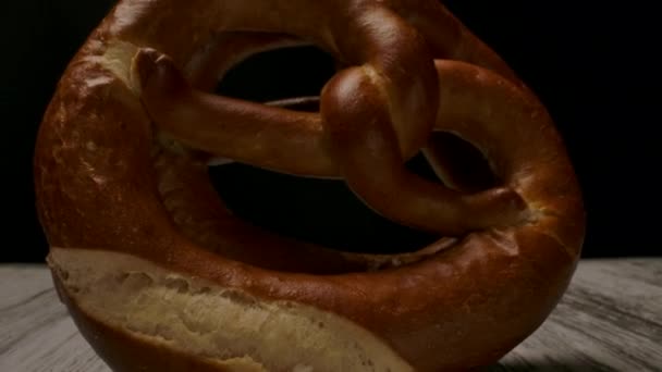 Delicioso pretzel colocado sobre mesa de madeira . — Vídeo de Stock