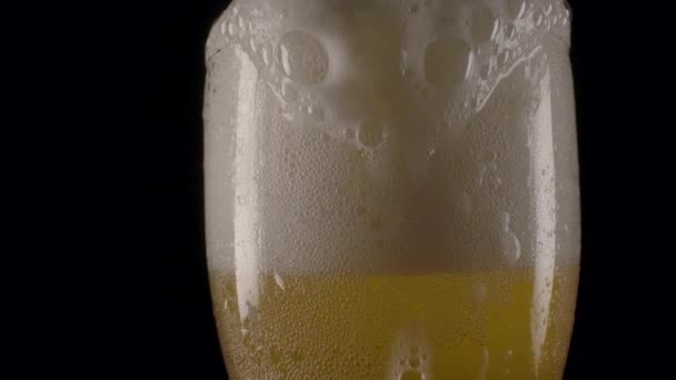 Bierschuim dat over de bekerrand stroomt. — Stockvideo