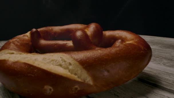 Hot pretzel colocado sobre mesa de madeira . — Vídeo de Stock