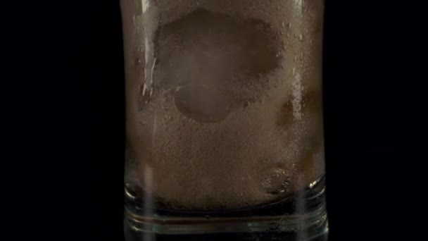 Mörk cola häller i glas med is. — Stockvideo