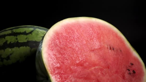 Skivad vattenmelon med röd pulpy på svart bakgrund — Stockvideo