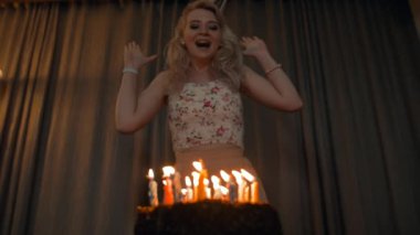 Güzel kadın mumlar şenlikli bir pastayı dışarı üfleme.