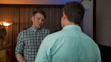 Şampanya içerken gülümseyen iki erkek.