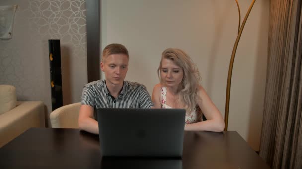 快乐的年轻夫妇在看平板电脑的时候笑了。在家里室内 — 图库视频影像
