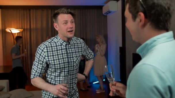 Chicos atractivos bebiendo champán y hablando en la fiesta de cumpleaños — Vídeos de Stock