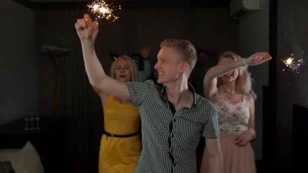 Grupo de pessoas felizes com cabeçalho masculino segurando sparklers na festa dançando e sorrindo . — Vídeo de Stock