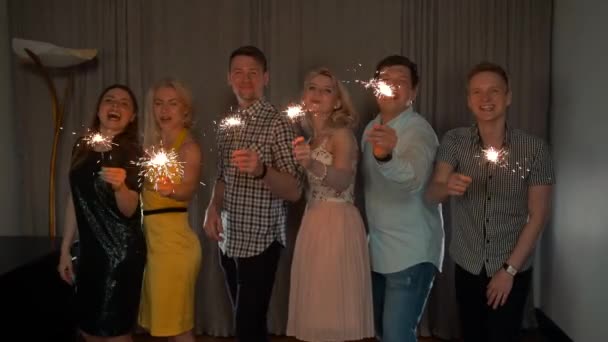 Group of cheerful young people carrying sparklers. — Stock Video