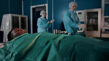 Two experienced surgeons in special robes come to the operating room