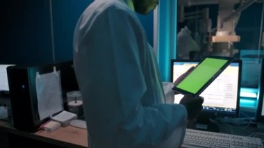 Laboratuvarda tabletten veri okuyan isimsiz siyah doktor