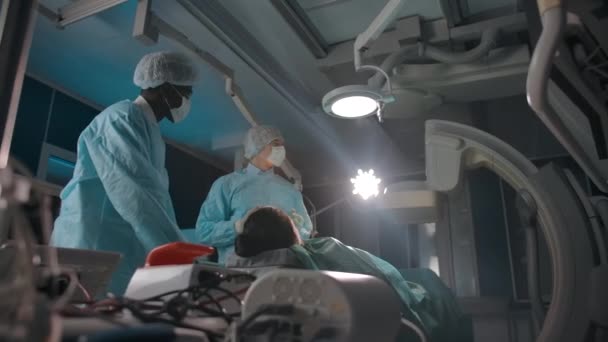 Diversos médicos examinan la pantalla durante la cirugía — Vídeo de stock