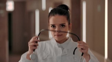 Kız terapist steteskobu boynuna doladı ve kameraya gülümsedi. 