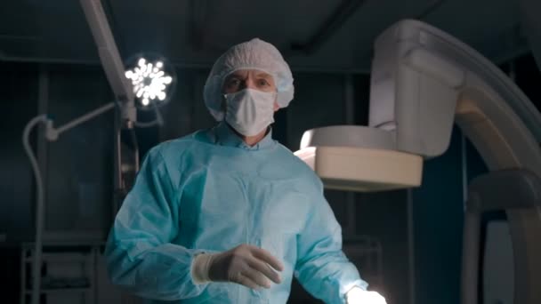 Tedbir maskesini çıkardıktan sonra ameliyattan sonra kendine güvenen beyaz cerrahın portresi — Stok video