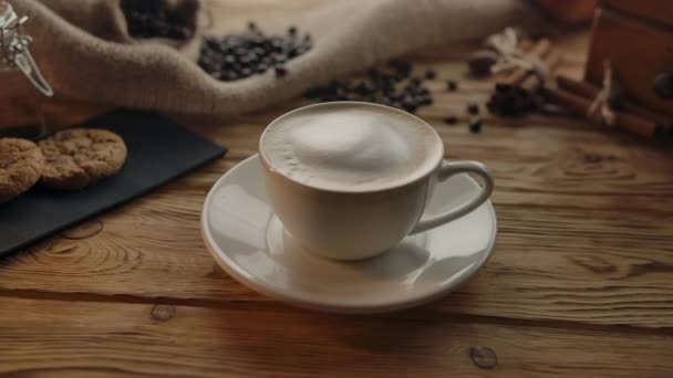 Taza de café con bebida de capuchino en la mesa de madera . — Vídeos de Stock