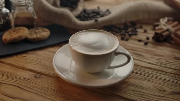 Taza de café girando sobre mesa de madera . — Vídeos de Stock