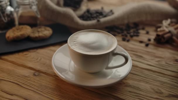 Taza de café con café con leche sobre mesa de madera . — Vídeos de Stock