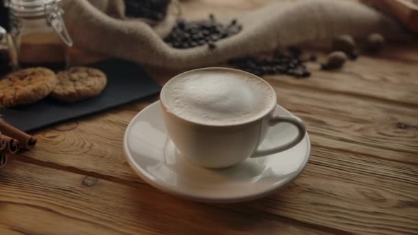 Камера обертається навколо чашки кави, взятої невпізнаваною жінкою — стокове відео