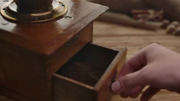 Personne méconnaissable prenant du café moulu d'un vieux moulin à café 