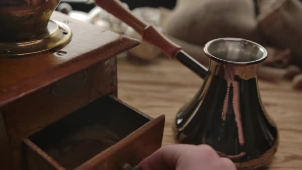 Неузнаваемый человек берет молотый кофе от старой кофемолки до дерзкой Cezve . — стоковое видео