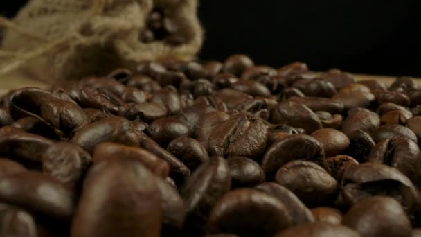 Makro utsikt över rostade kaffebönor och jutesäck — Stockvideo