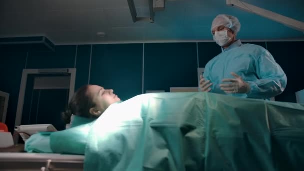 Doktor ameliyathanede hastayla konuşuyor.. — Stok video