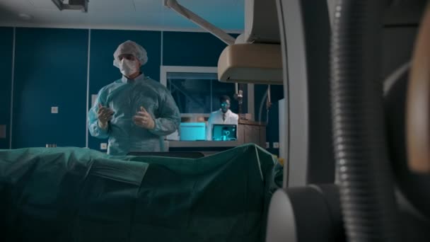 Cirujano masculino haciendo un gesto OK al médico que está siendo preparado para la operación — Vídeos de Stock