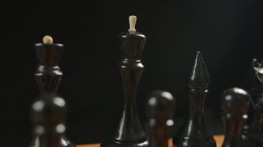 Başlangıç pozisyonunda tahta dama tahtasındaki siyah satranç taşları