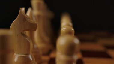 Dama tahtasında beyaz tahta satrancın makro görüntüsü. Şövalyeden krala yeniden odaklanmak..