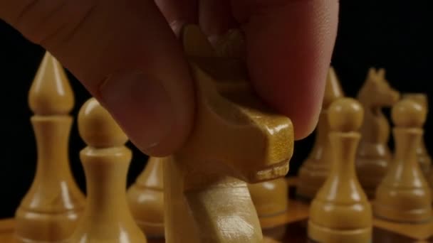 Mão dos homens coloca um cavaleiro na célula tabuleiro de xadrez — Vídeo de Stock