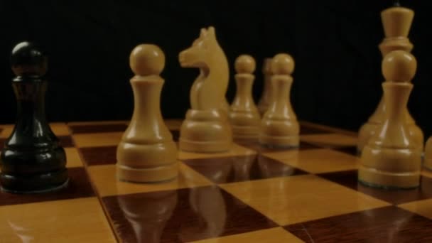 Mens hand puts a bishop figure on checkerboard cell — Stock Video