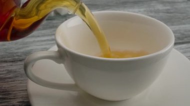 Çaydanlıktan bir fincan üzerine siyah çay dökmek.