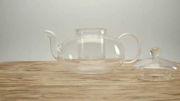 Sprinkling dry white authentic tea into a transparent teapot — Stock Video
