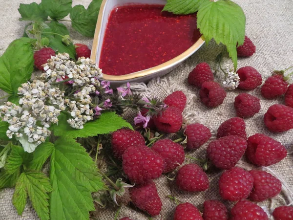 Raspberry jam with fresh raspberry and flowers.