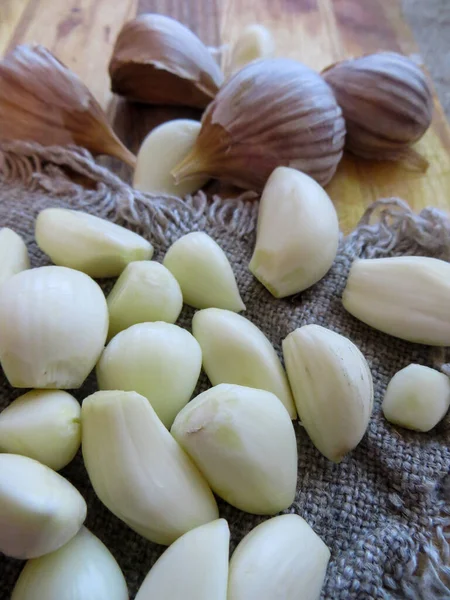 Una cabeza de ajo fresco y dientes de ajo pelados . —  Fotos de Stock