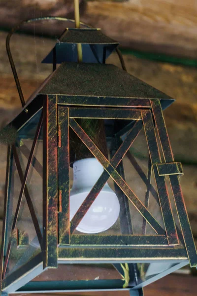 Uma velha lanterna de ferro é anexada a um teto de madeira . — Fotografia de Stock