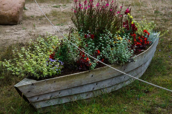 Um velho barco de madeira desatualizado, usado para decorar o jardim . — Fotografia de Stock