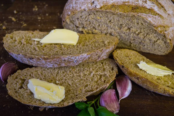 Plasterki świeżego chleba z plasterkami masła i ząbki czosnku. — Zdjęcie stockowe
